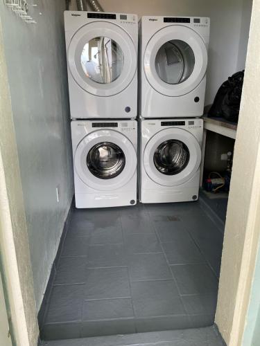 two washing machines and a washer and dryer in a room at Tropical Pool Villa with Big Views and Lush Gardens in Coral Bay