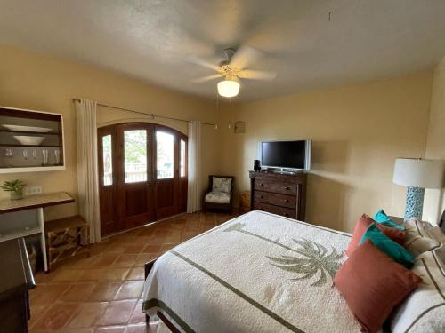 a bedroom with a bed and a ceiling fan at Tropical Pool Villa with Big Views and Lush Gardens in Coral Bay