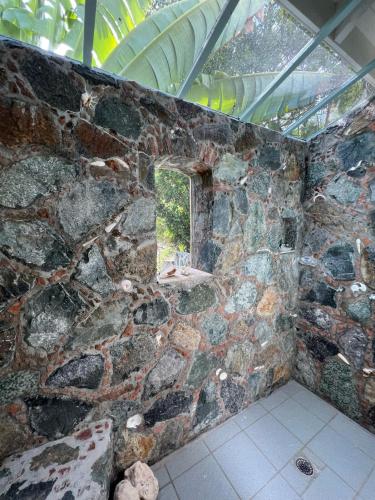 a room with a stone wall with a window at Tropical Pool Villa with Big Views and Lush Gardens in Coral Bay