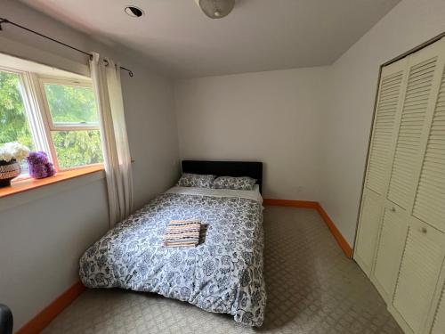 a bedroom with a bed with a comforter and a window at Sweet Home in Vancouver