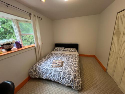 a bedroom with a bed and a window at Sweet Home in Vancouver