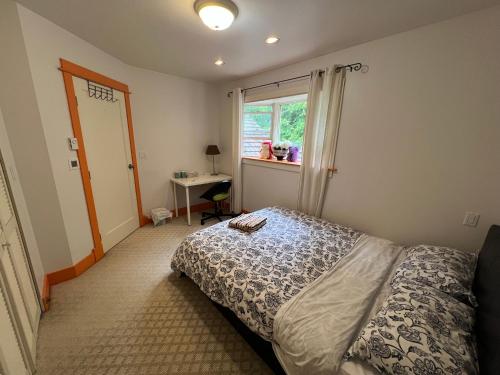 a bedroom with a bed and a window and a desk at Sweet Home in Vancouver