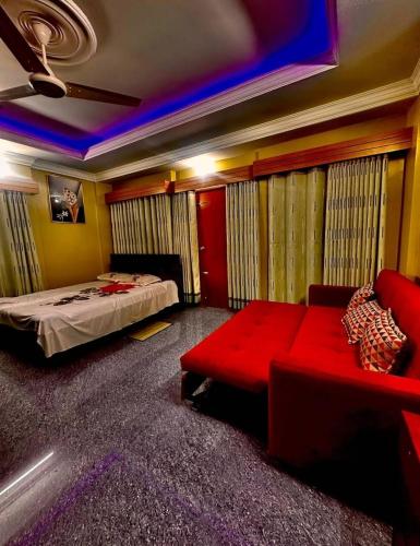 a bedroom with a bed and a red couch at Dream Holiday Resort in Ināni