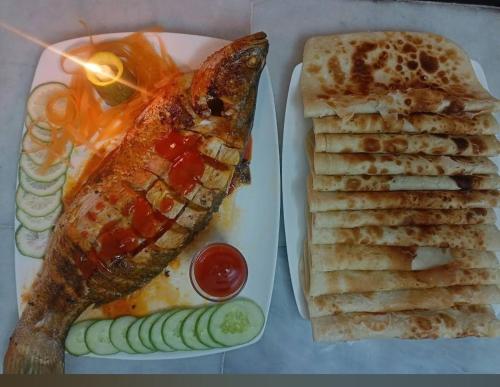een bord eten met vis en brood bij Dream Holiday Resort in Ināni