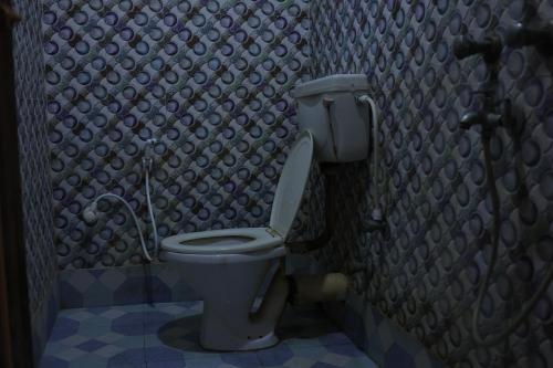 a small bathroom with a toilet in a room at Hotelswapnoneer in Diamond Harbour