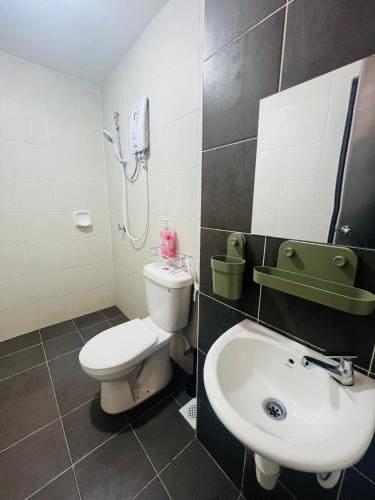 a bathroom with a white toilet and a sink at Khasif Amani Homestay Parit Buntar in Parit Buntar