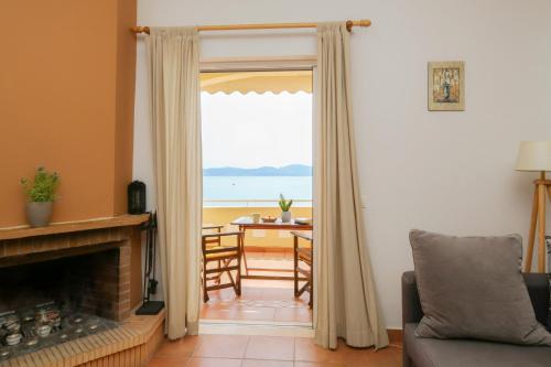 a living room with a fireplace and a view of the ocean at Kiveri Gems Houses in Kivérion