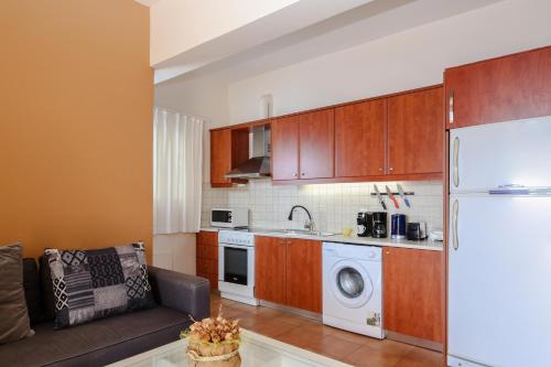 a kitchen with a couch and a white refrigerator at Kiveri Gems Houses in Kivérion