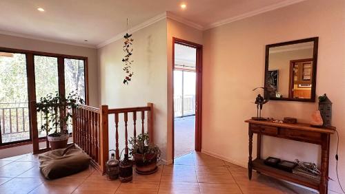 a living room with a staircase and a mirror at Oceana Suites Laguna de Aculeo in Paine