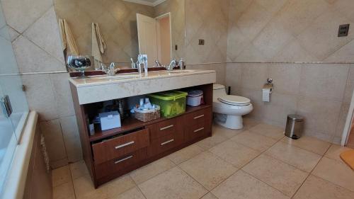 a bathroom with a sink and a toilet at Oceana Suites Laguna de Aculeo in Paine
