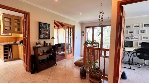 a living room with a staircase and a desk at Oceana Suites Laguna de Aculeo in Paine
