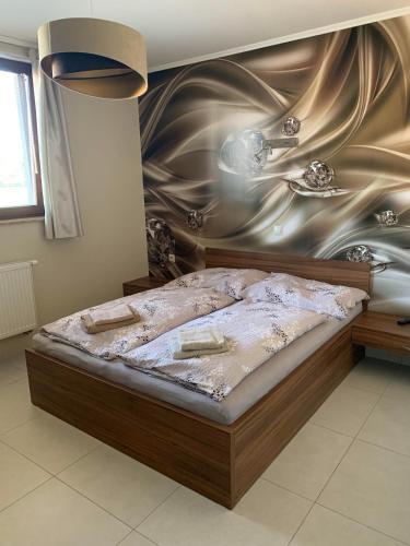 a bedroom with a large bed with a wall at Vila Lexus in Veľký Meder