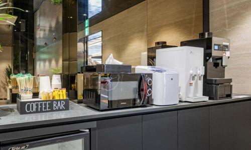 a coffee shop counter with a coffee bar on it at Yeongdeungpo Lifestyle F Hotel in Seoul