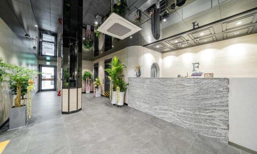 a lobby with a marble counter and potted plants at Yeongdeungpo Lifestyle F Hotel in Seoul