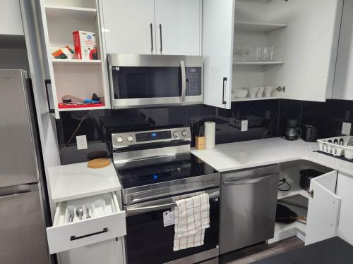 een keuken met een fornuis en een magnetron bij Home Away from Home 2 bedrooms in Edmonton