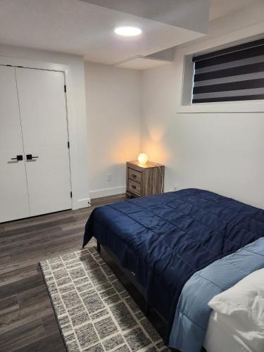 een slaapkamer met een bed, een ladekast en een raam bij Home Away from Home 2 bedrooms in Edmonton