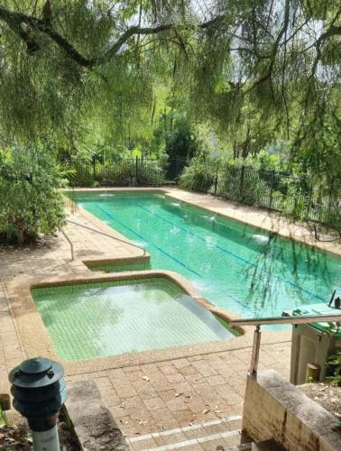 a swimming pool in a yard with a tree overhead at Beach-Pool-Tennis-Ocean Views-All at Your Door in Surf Beach