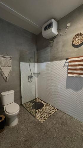 a bathroom with a shower with a toilet and a glass shower stall at Cozy villa 2bdr in Seminyak , pool,800m beach in Seminyak