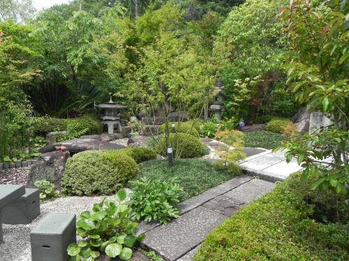 a japanese garden with a stone walkway at ガーデンリゾート 潮美庵 in Hatsukaichi