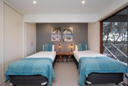 two beds in a room with a balcony at Hopewell House with Spa and Golf Course Views in Saint Andrews Beach
