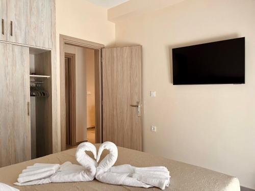 two towels in the shape of hearts sitting on a bed at The 52 Spot in Kos Town