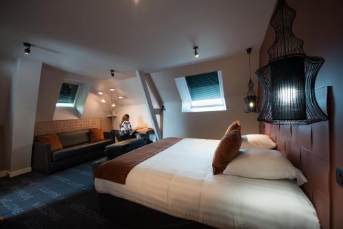 um quarto de hotel com uma cama e uma sala de estar em Saint Georges Hotel & Spa em Chalon-sur-Saône