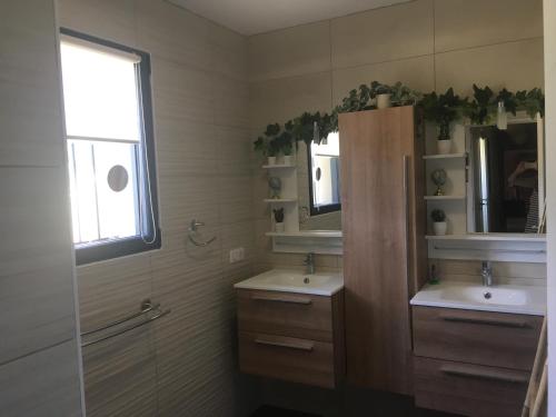 une salle de bain avec deux lavabos et une fenêtre dans l'établissement VILLA en Drome Provencale, à Piégon