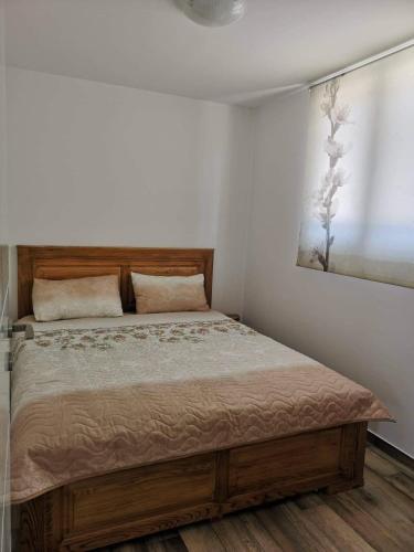 a bedroom with a bed with a painting on the wall at Garten House in Kornić