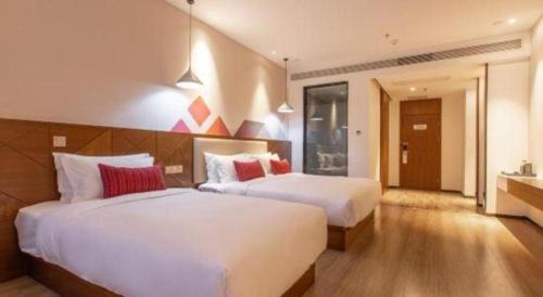 two beds in a hotel room with two beds sidx sidx sidx at Borrman Hotel Guilin Railway Station Two Rivers and Four Lakes in Guilin
