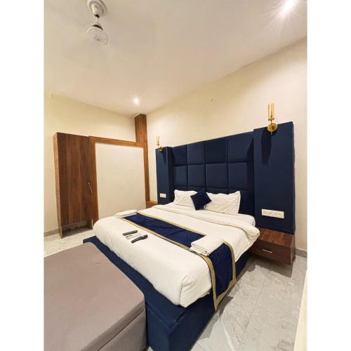 a large bed with a blue headboard in a room at Hotel Royal Palm Inn in Faizābād