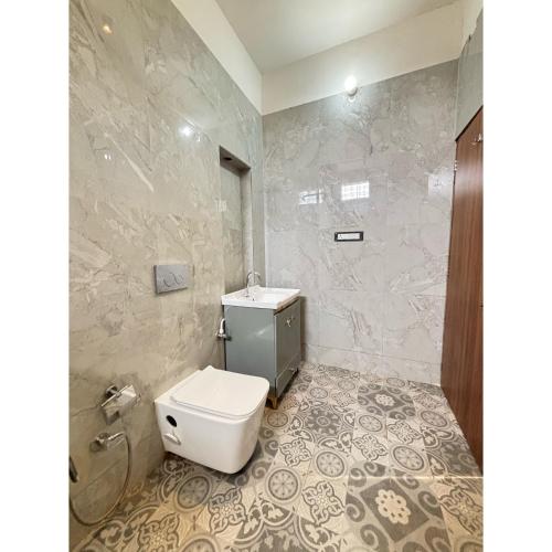 a bathroom with a white toilet and a shower at Hotel Royal Palm Inn in Faizābād