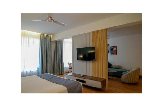 罗纳瓦拉Ikshana Resort and Spa, Khandala的一间配有床和平板电视的酒店房间