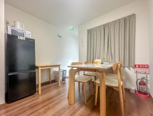 a kitchen and dining room with a table and a refrigerator at HANASTAY花渓居 · 澄（KIYOSI) in Osaka
