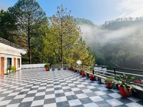 a balcony with potted plants and a view of a mountain at The Shalam Resort श्रीकृष्ण शरणं मम in Lansdowne