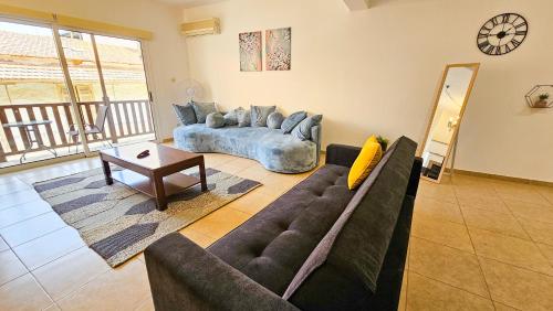 a living room with a couch and a table at SKY Way City Apartment, 150m from Chabad Lubavitch in Larnaca