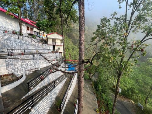 a group of bleachers with a tree in the foreground at The Shalam Resort श्रीकृष्ण शरणं मम in Lansdowne