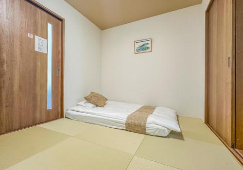 a small room with a bed in the corner at HANASTAY花渓居 · 川（KAWA） in Osaka