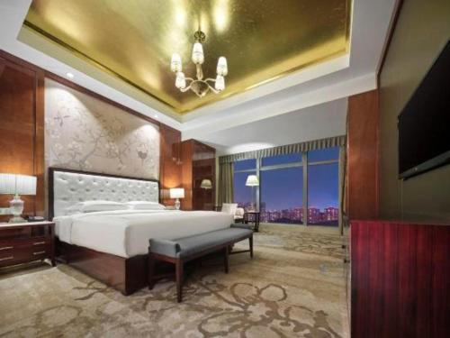 a large bedroom with a bed and a television at Dongwu New Century Grand Hotel Huzhou in Huzhou