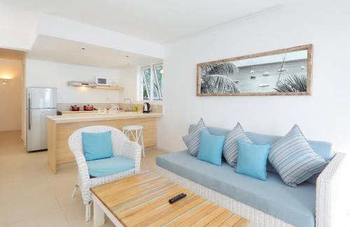 a living room with a couch and a table at Le Beachclub in Pereybere