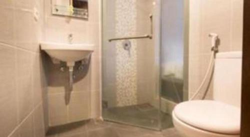 a bathroom with a shower and a toilet and a sink at Hadi Poetra Hotel in Kuta