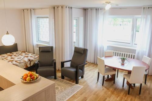 um quarto com uma mesa e cadeiras e um quarto em Metsa 49 Apartment em Haapsalu