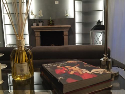 ローマにあるBig Tree Luxury Apartmentの本の横のテーブルに座るワイン1本