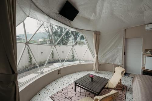 a room with a table and a large window at Kaung Cabins in Cibogo