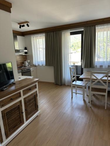 a living room with a kitchen and a dining room table at House Egger - Top 202 in Bad Kleinkirchheim