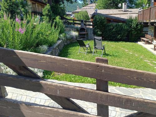 two chairs in a yard behind a wooden fence at Sauze d'Oulx ciabot la garitüla with garden - wifi- close to the chairlift in Sauze dʼOulx