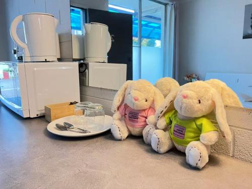 three stuffed rabbits sitting on a counter in a kitchen at Motel Maroondah in Box Hill