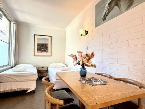 a room with a table and two beds at Motel Maroondah in Box Hill