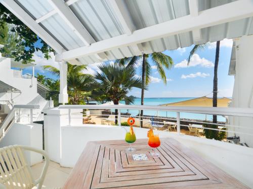 a table on the balcony with a view of the ocean at Le Beachclub in Pereybere
