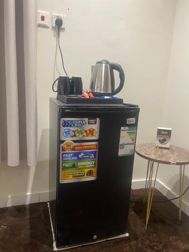 a small refrigerator with a tea kettle on top of it at شقة أنيقة غرفة وصالة بأثاث فندقي in Dammam