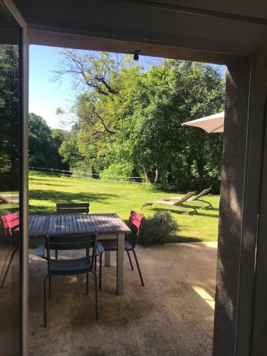 a patio with a table and chairs in a yard at L'Atelier, Confort, Bain à remous et Nature in Parisot-Tarn-et-Garonne